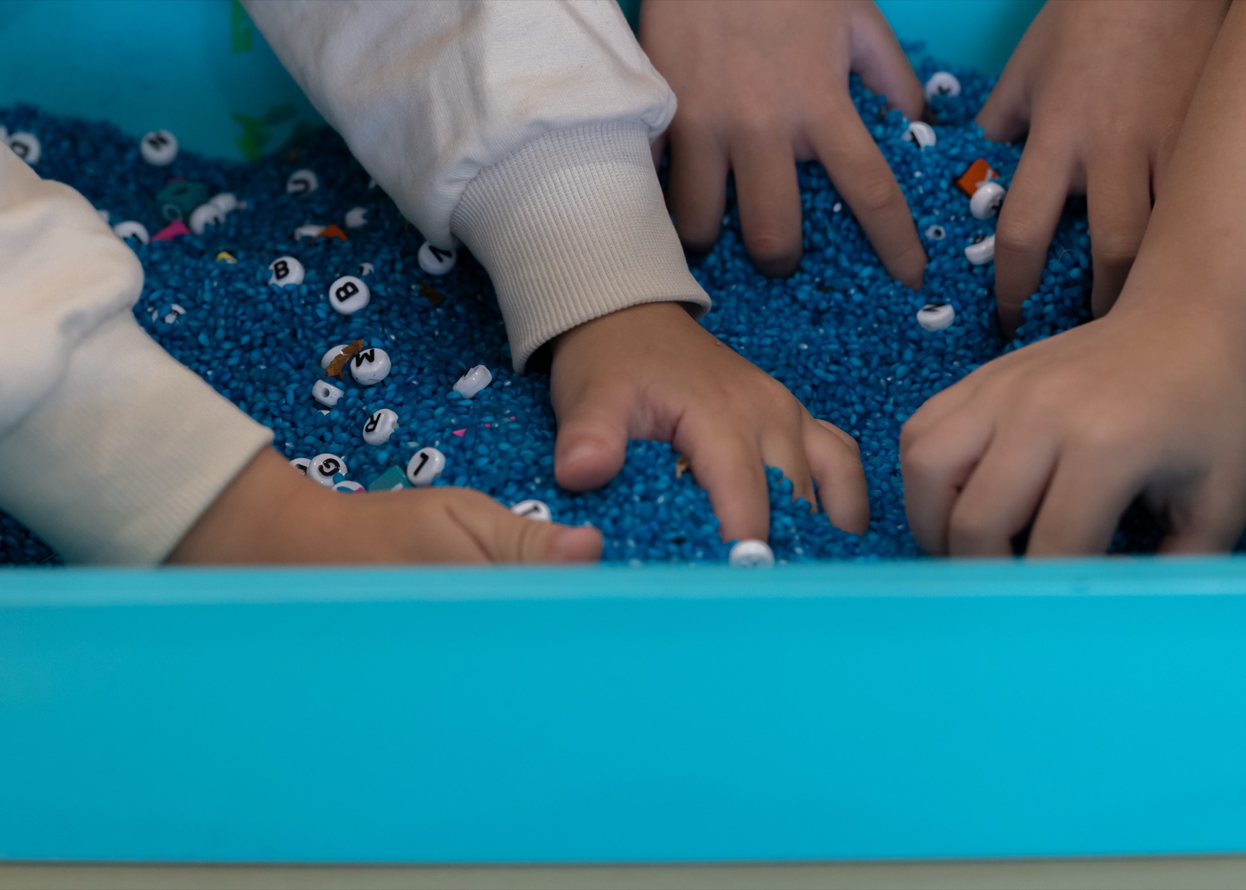 Small hands exploring a sensory tray